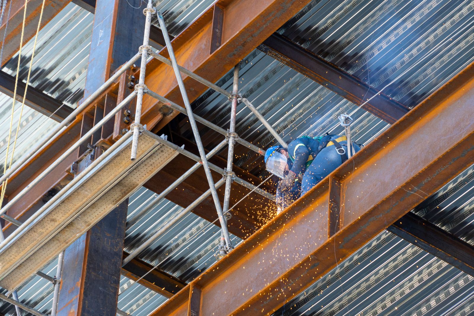 Welder joining structural steel beams